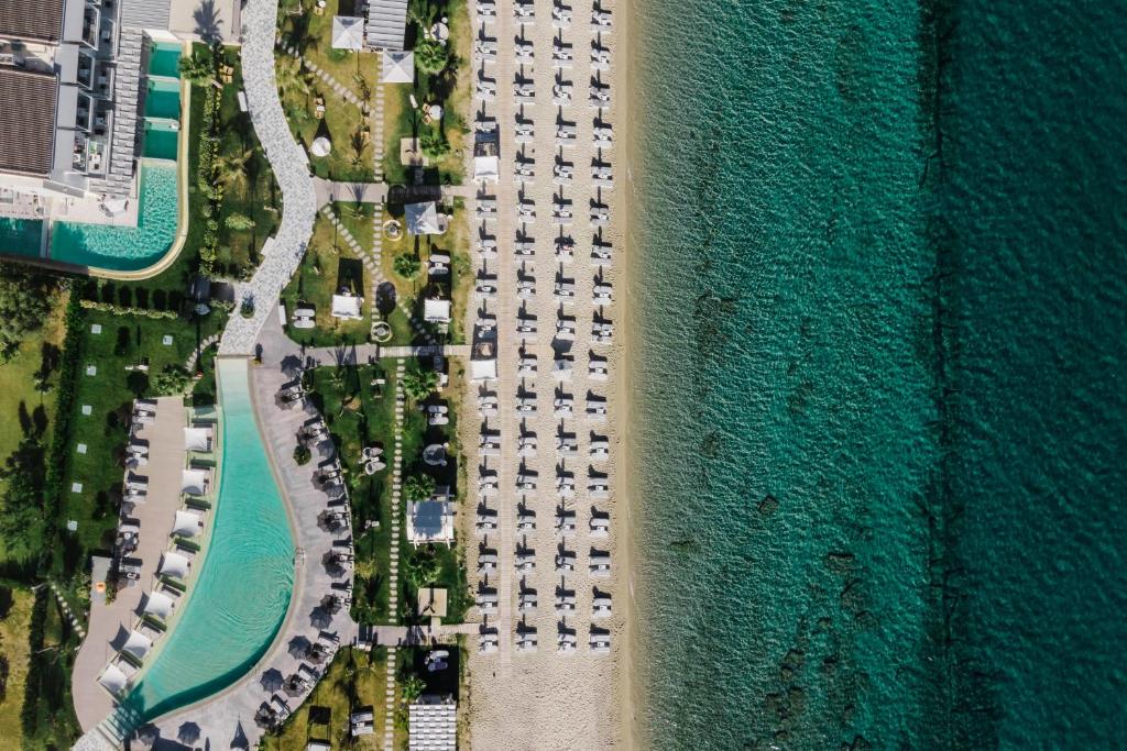 佩科霍里Blue Carpet Luxury Suites的享有毗邻大海的停车场的空中景致