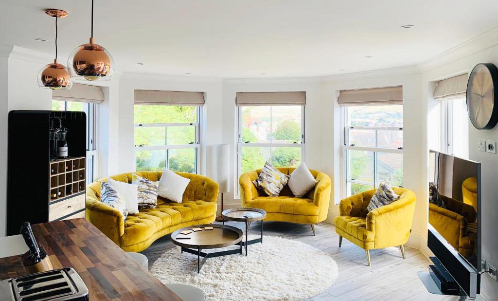 斯沃尼奇The Lookout的客厅配有两张黄色的沙发和一张桌子