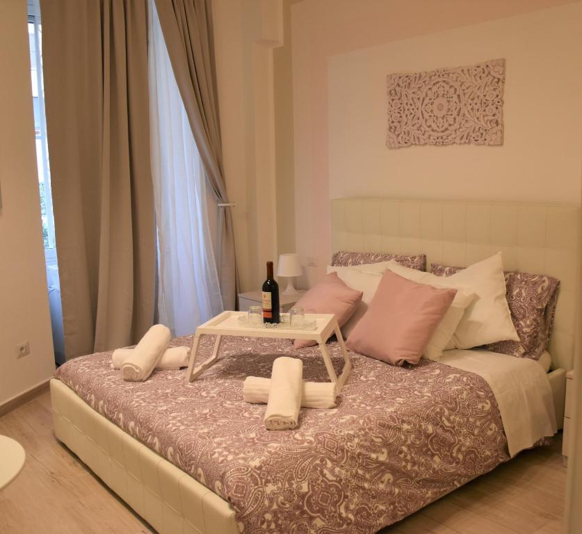 罗马Lovely Nights Rome - Luxury rooms的一张带桌子的床,上面有一瓶葡萄酒