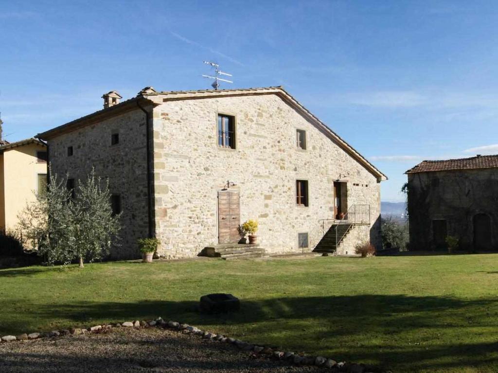 安吉亚里Appartamenti con cucina nelle colline toscane的一座古老的石头建筑,上面有十字架