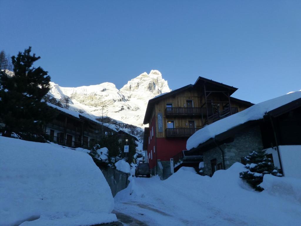 布勒伊-切尔维尼亚霍斯奎特酒店的一座雪覆盖的村庄,后面有一座山