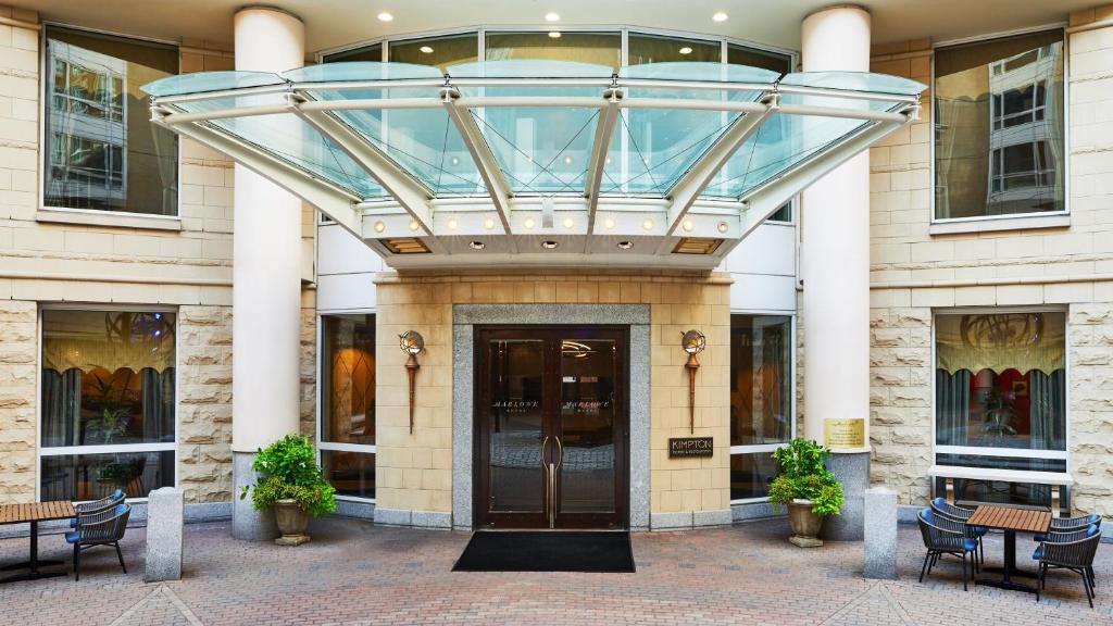 剑桥Kimpton Marlowe, an IHG Hotel的带有旋转门的建筑物的玻璃入口