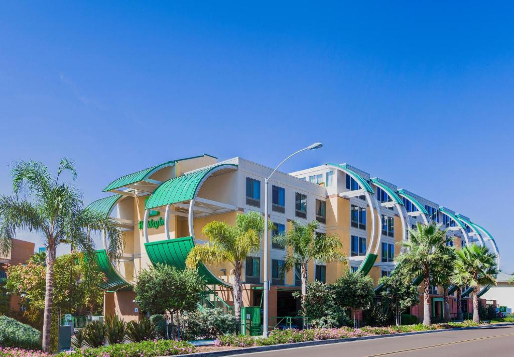 奥欣赛德Holiday Inn Oceanside Marina Camp Pendleton, an IHG Hotel的街道前方有棕榈树的建筑