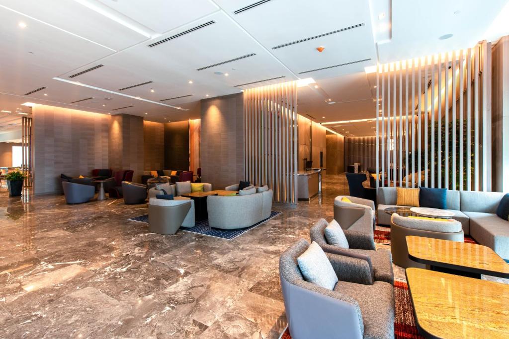 新山Holiday Inn Johor Bahru City Centre, an IHG Hotel的大厅,在大楼里设有沙发和桌子