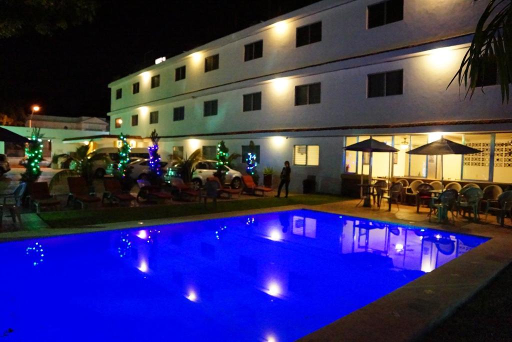 梅里达拉斯达利亚斯酒店的一座游泳池,在晚上在建筑物前