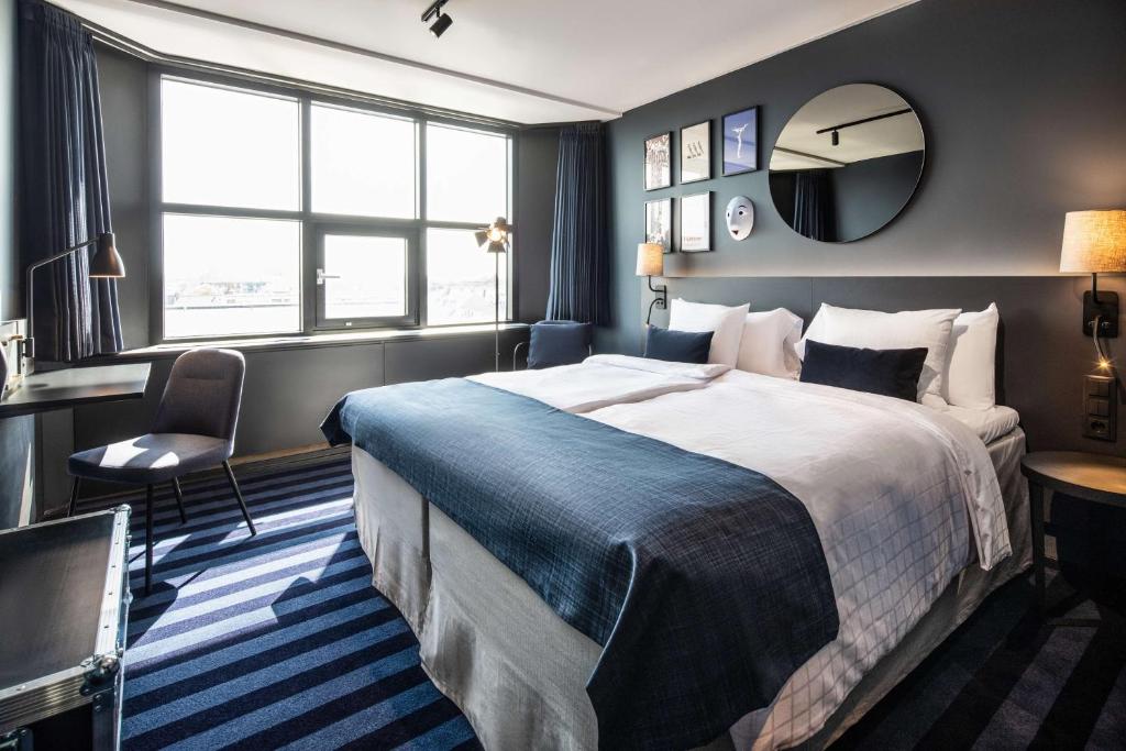 哥本哈根Scandic Falkoner的配有一张大床和镜子的酒店客房