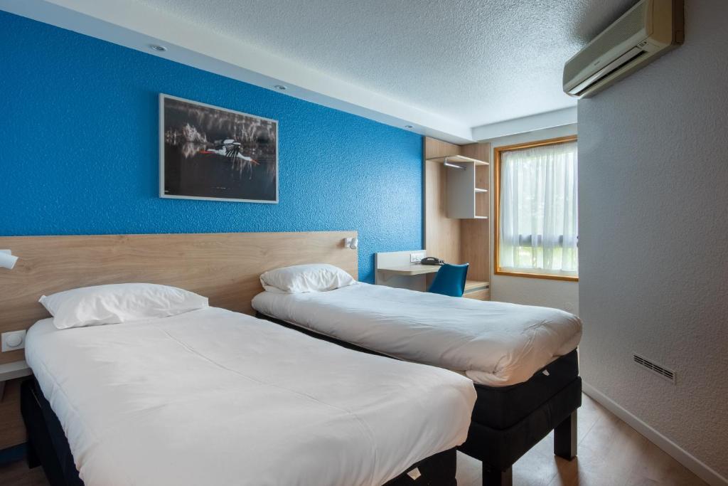 米卢斯Brit Hotel Mulhouse Centre的两张位于酒店客房的床,拥有蓝色的墙壁