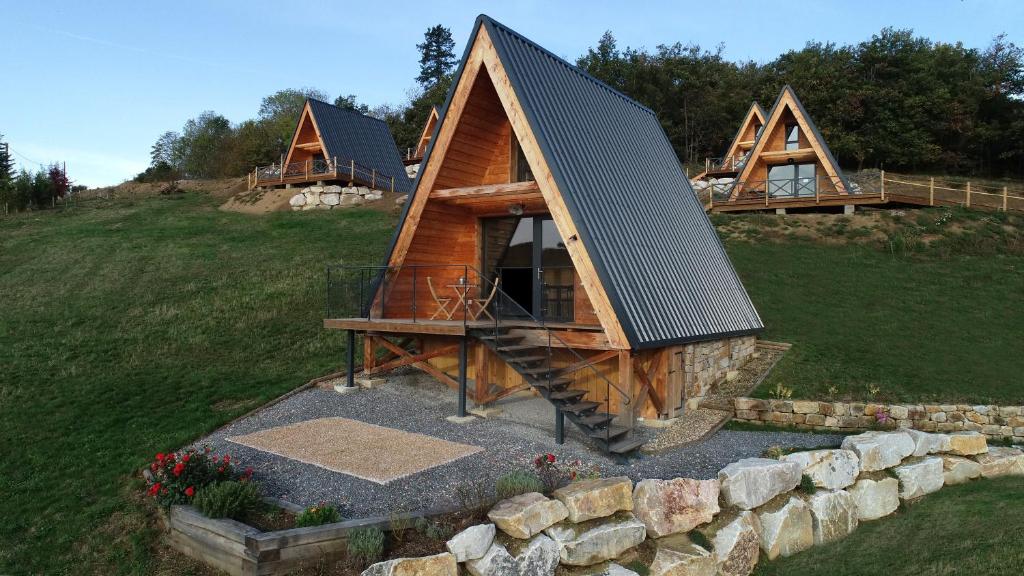 Saint-Christo-en-JarezÔ TIPI LODGE的山坡上带金属屋顶的小屋