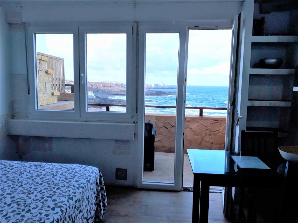 特尔德One room flat at the beach near house "Sanmao"的一间卧室配有一张床,享有海景