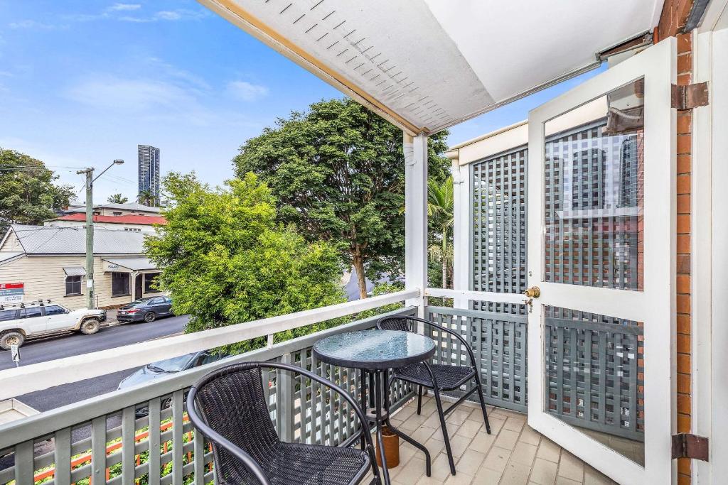 布里斯班Spring Hill Terraces的阳台配有桌椅,享有街道的景色。