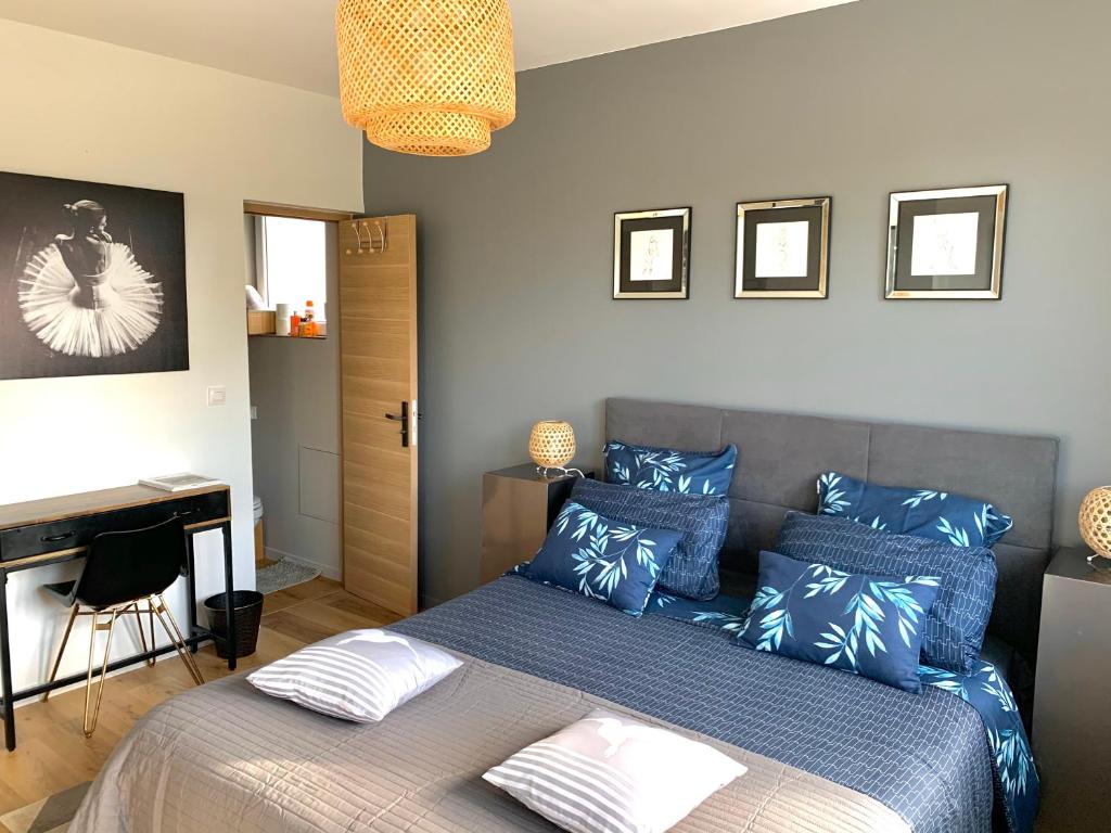 马尔康巴勒尔La Demeure Marcquoise的一间卧室配有一张带蓝色枕头的床和一张书桌