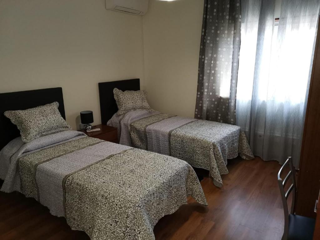 佩纳科瓦Apartamento Mondego的一间卧室设有两张床和窗户。