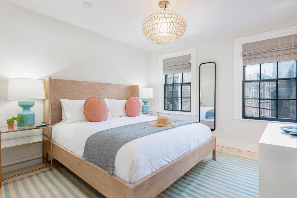 楠塔基特Nantucket Resort Collection的一间卧室设有一张大床和两个窗户。