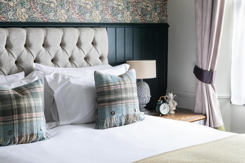 赛伦塞斯特赛伦塞斯特羊毛宾馆 的卧室配有白色的床、床头板和枕头。