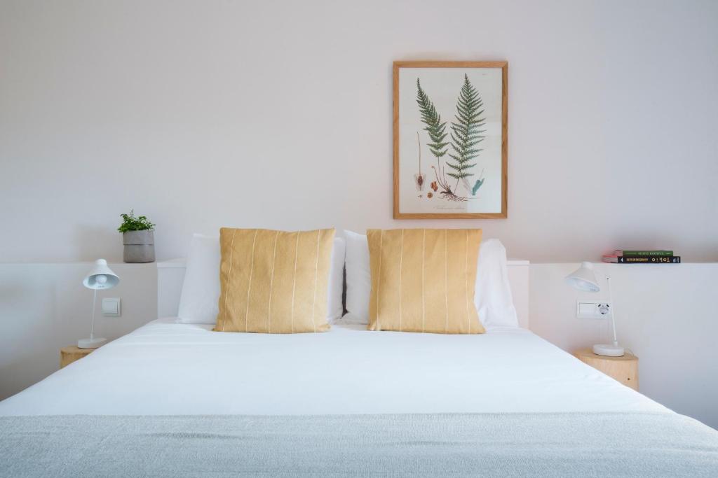 TivissaHotel Rural Mas de l'Illa的卧室配有白色的床和2个枕头