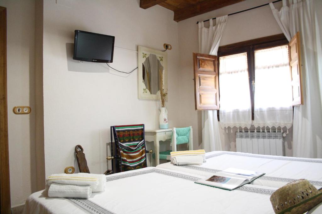 托雷洪厄尔卢比奥Alojamiento la cañada monfrague的一间卧室设有两张床,墙上配有电视。