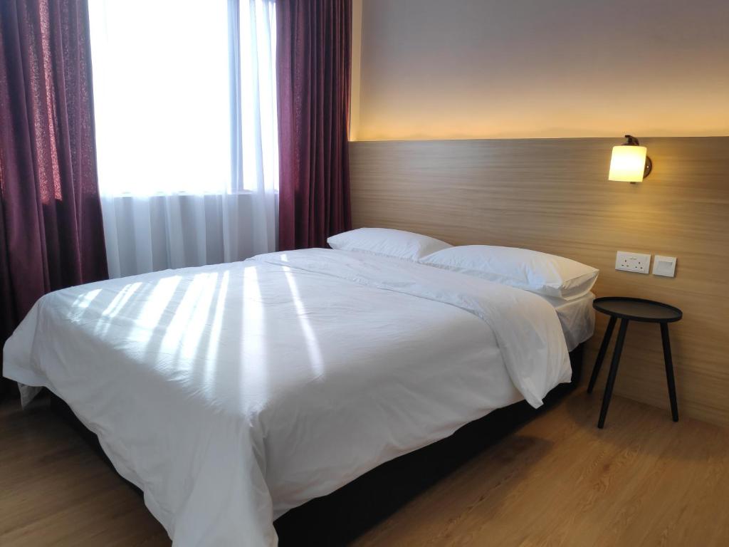 斯里巴加湾市EZ Suites的卧室配有一张大白色床和窗户