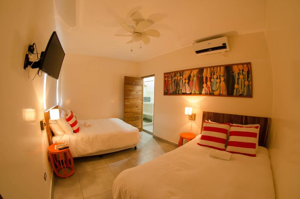 南圣胡安El Caite San Juan del Sur的一间酒店客房,设有两张床和电视