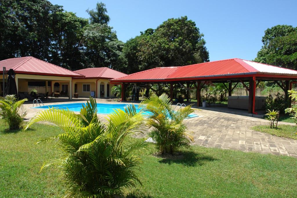 帕拉马里博Kekemba Apartments Paramaribo的一个带游泳池和红色屋顶的度假胜地