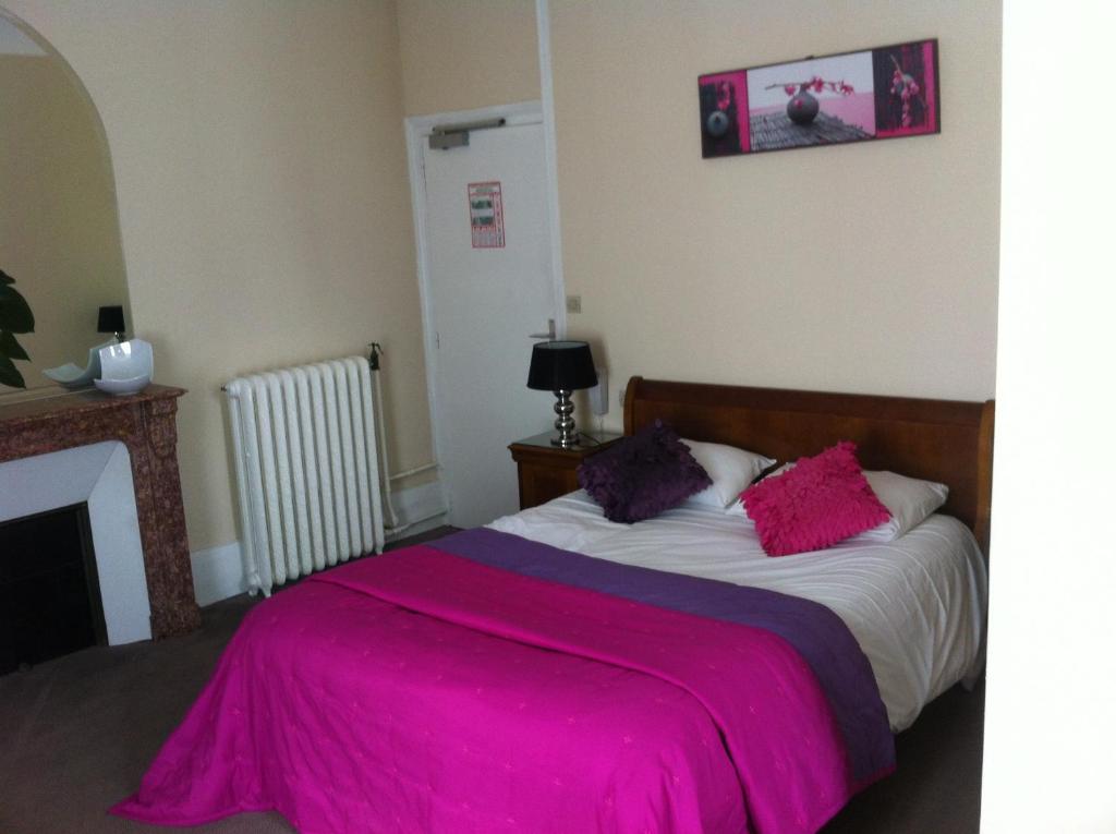 日安拉普尔拉德酒店的一间卧室配有一张带粉色毯子的床
