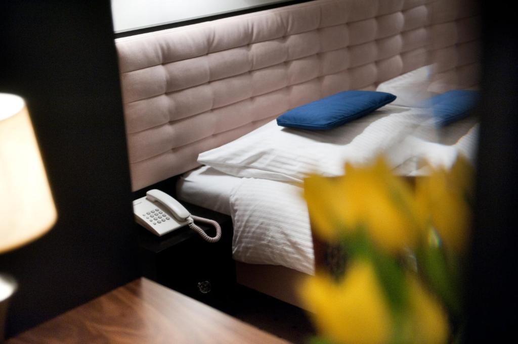 卢布林福克斯酒店的一间卧室配有一张带蓝色枕头的床