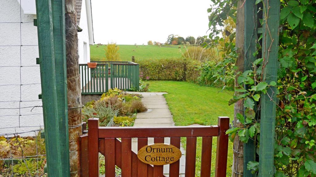比尤利Ornum Cottage的花园中的木凳上标有标志