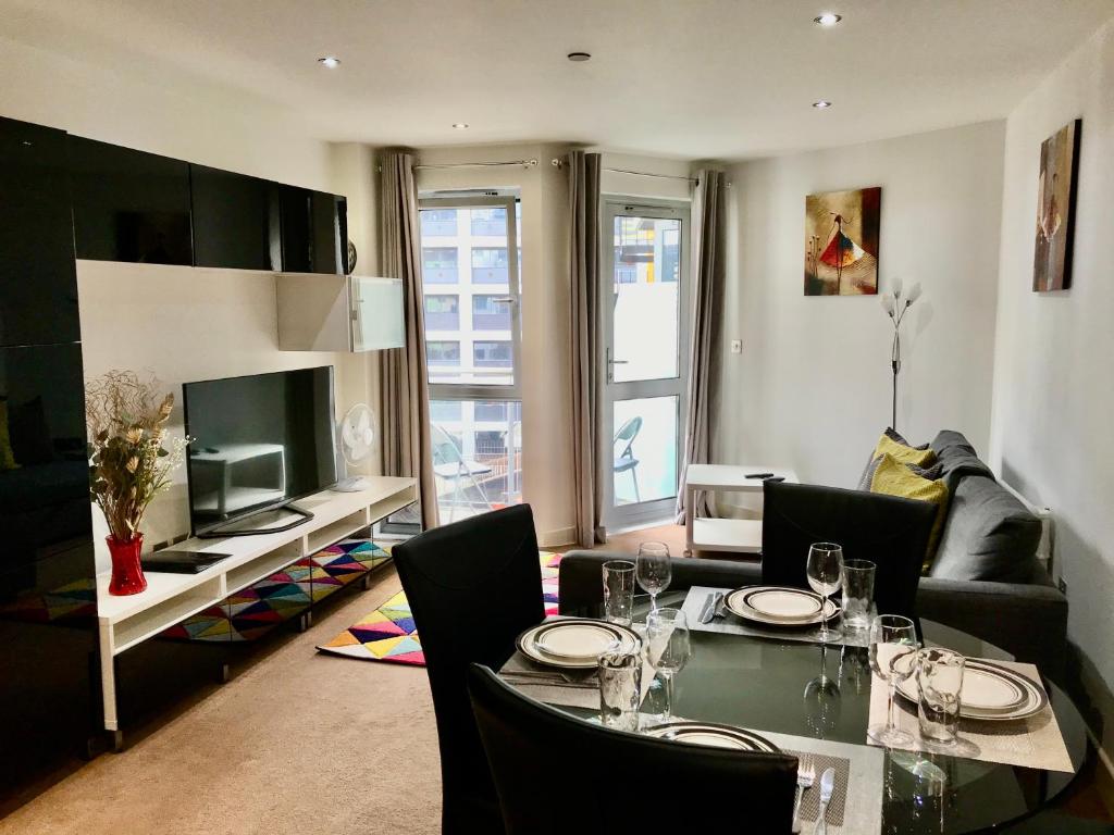 布里斯托马什之家公寓的客厅配有餐桌和电视
