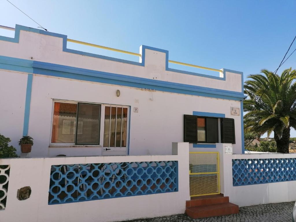 卡拉帕泰拉Casa do Lado的白色的房子,有蓝色的修剪和栅栏