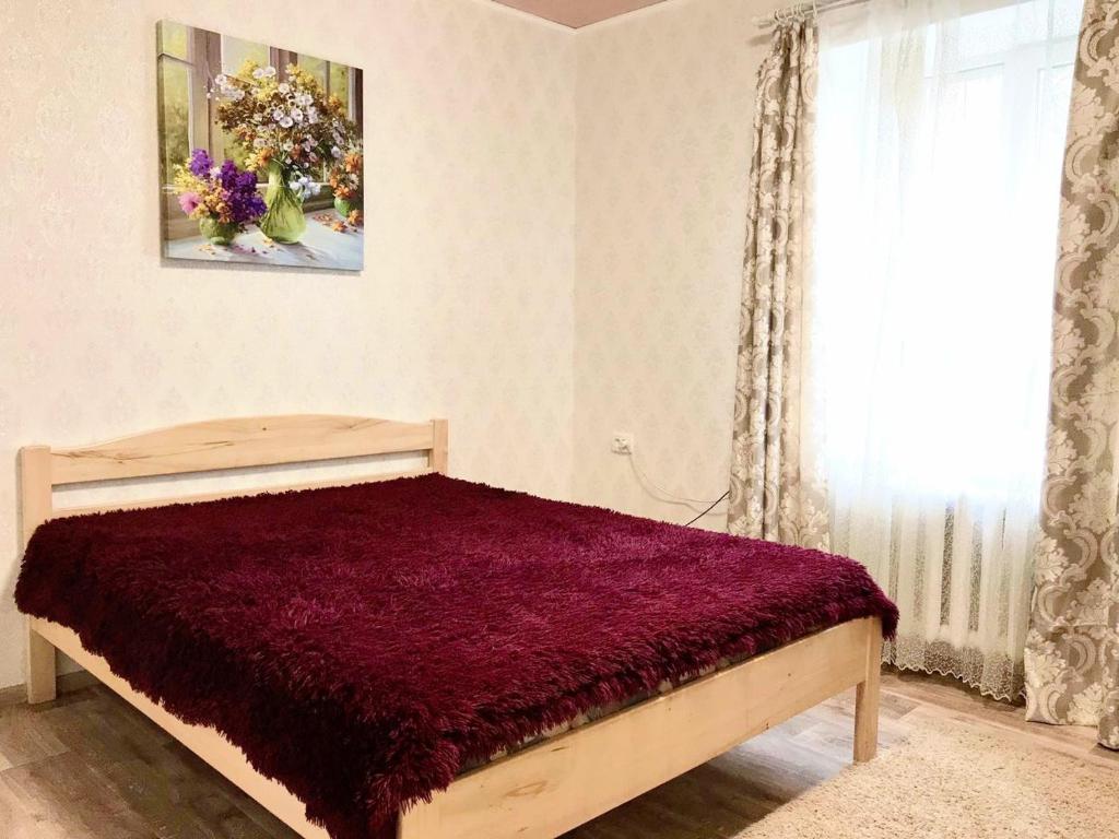 克洛佩夫尼茨基Шевченко двор的一间卧室配有一张红色棉被的床