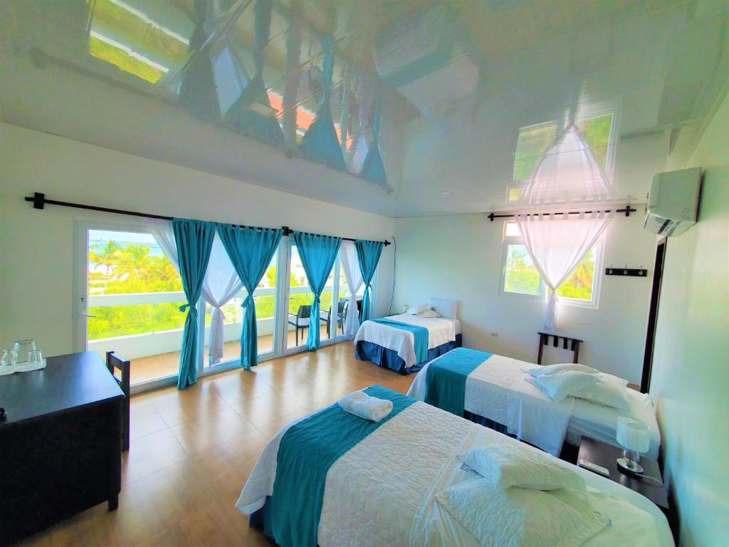 比亚米尔港Hotel Cally的一间卧室设有两张床和蓝色窗帘