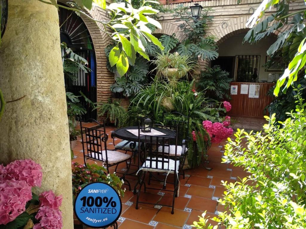 科尔多瓦罗斯阿克斯酒店的庭院配有桌椅和鲜花