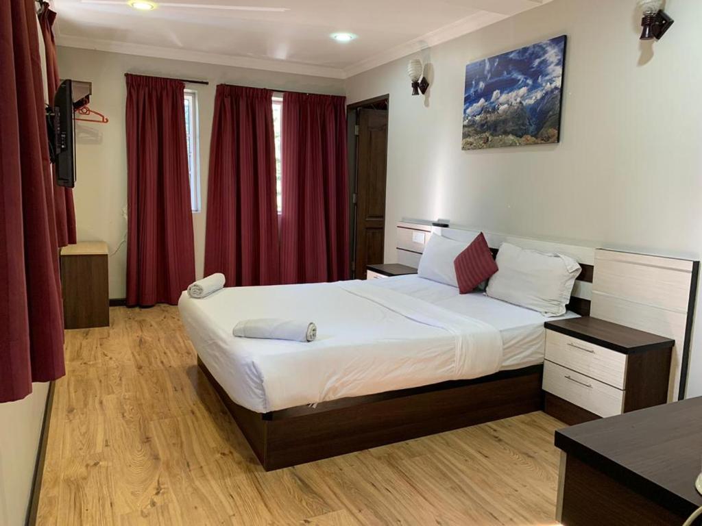 金马仑高原采尔马特酒店 的一间卧室配有一张带红色窗帘的大床