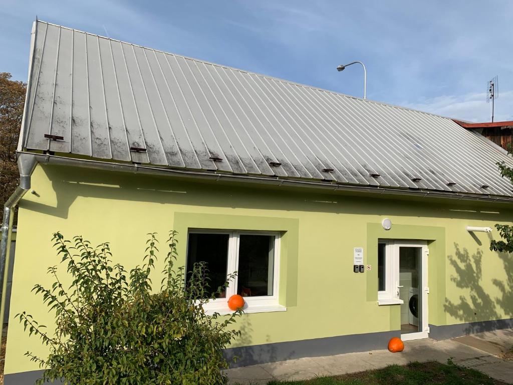 马达伯乐斯拉夫Apartmány Kosmonosy, Hradištská 193的一座带太阳能屋顶的绿色房子