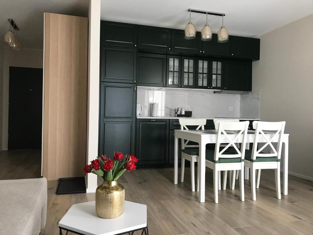 格但斯克Baltica Sea Apartment II的厨房以及带桌椅的起居室。