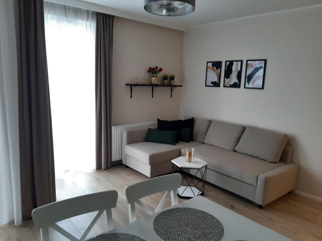 格但斯克Baltica Sea Apartment II的客厅配有沙发和桌子