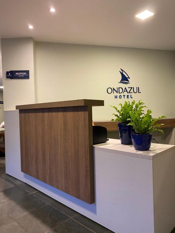 瓦伦萨Hotel Onda Azul的一家拥有两株盆栽植物的酒店的一个前台