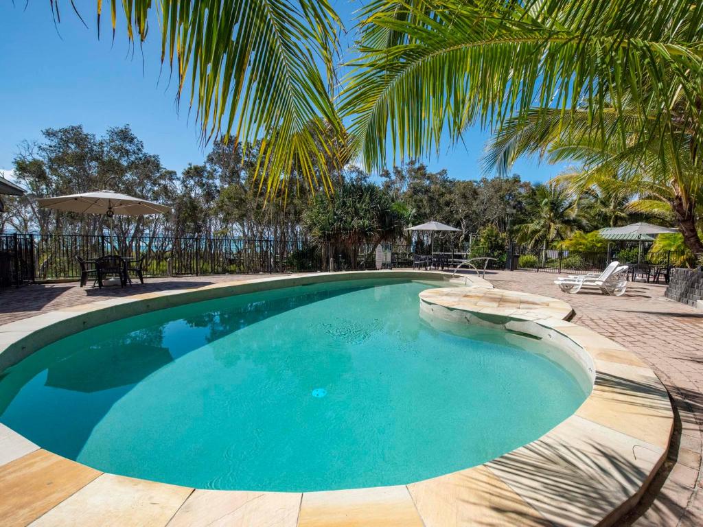 波因特卢考特斯特拉迪安克雷奇酒店的旁边是一座棕榈树游泳池