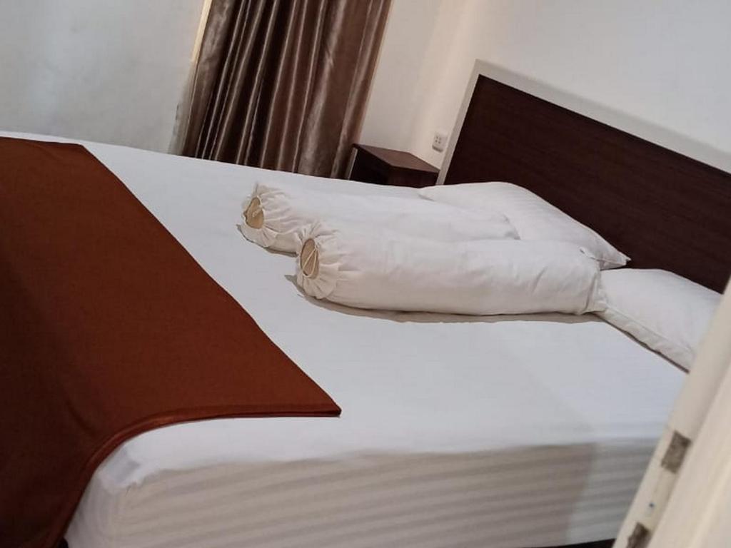 BiromaruFidelia Homestay Palu Mitra RedDoorz的一间卧室配有带白色枕头的床