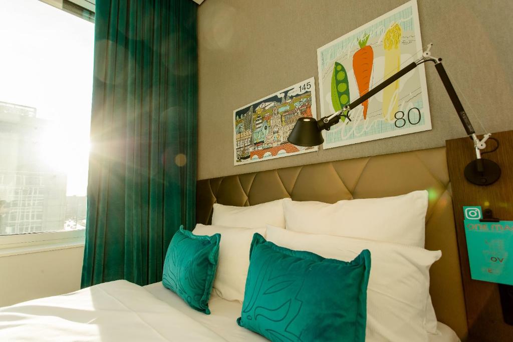 莱比锡Motel One Leipzig-Post的一间卧室配有一张带蓝色和白色枕头的床
