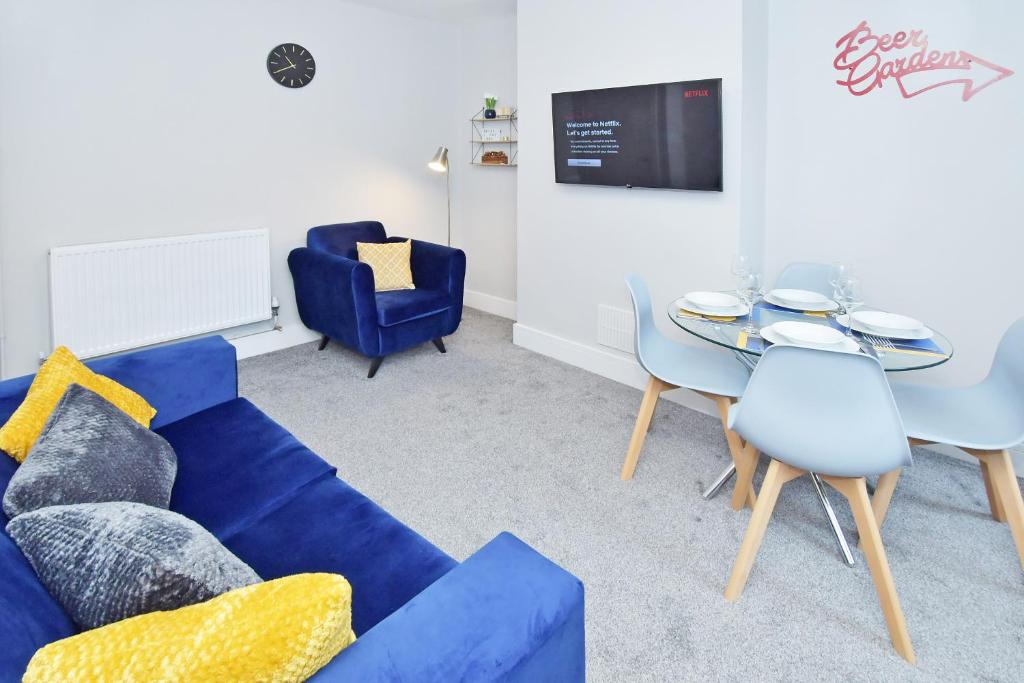 Trent ValeTownhouse @ 543 London Road Stoke的客厅配有蓝色的沙发和桌子