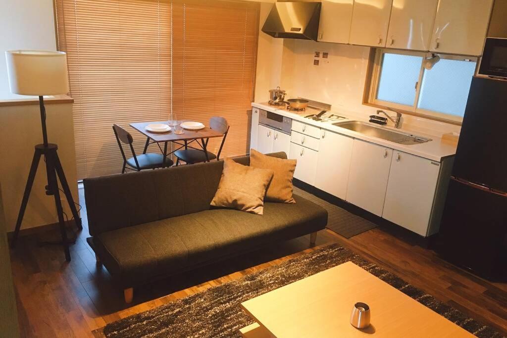 东京Chill Inn Honan的带沙发的客厅和厨房