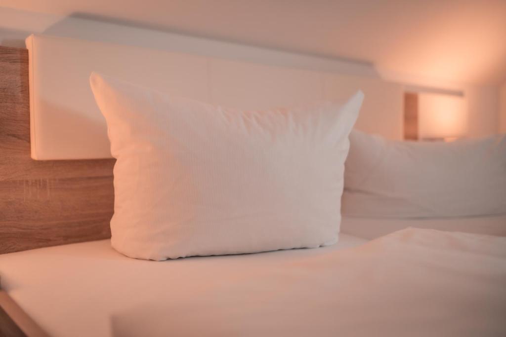 杜塞尔多夫Airport Lounge Hotel Düsseldorf的床上的白色枕头