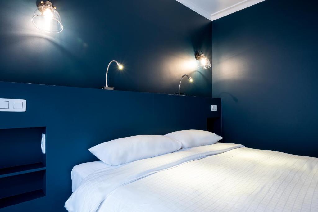 布鲁塞尔贝弗利山酒店的蓝色卧室配有白色床和2个枕头