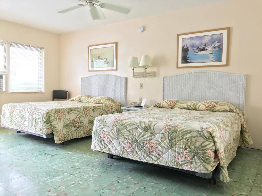 基韦斯特艾尔派提奥汽车旅馆的一间卧室配有两张床和一张带风扇的桌子。