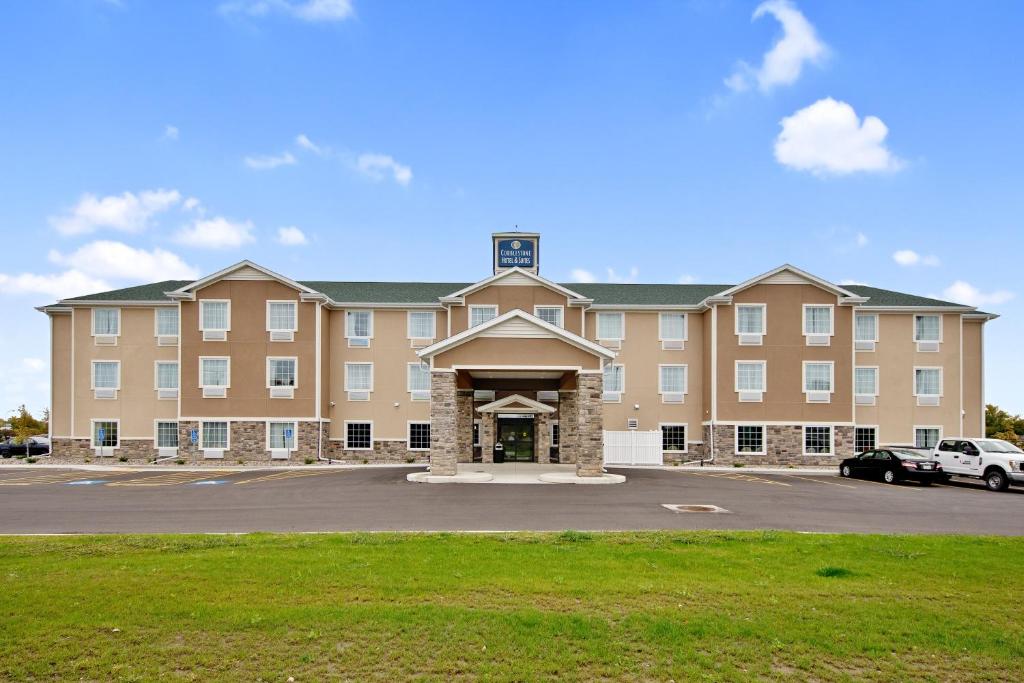 奥斯汀Cobblestone Hotel & Suites - Austin的一座大型建筑,前面设有停车场