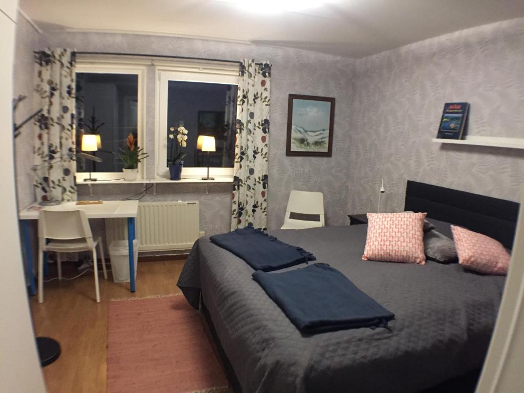 马尔默Dubbelrum med extrasäng på markplan i lugnt villaområde的一间卧室配有一张床、一张桌子和一个窗户。