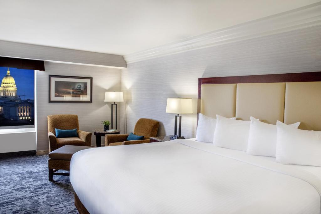 麦迪逊麦迪逊广场酒店的酒店客房带一张大床和椅子