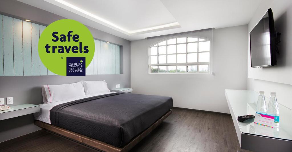 墨西哥城肯格乐索麦克斯酒店的一间卧室,配有一张床和一个安全旅行标志