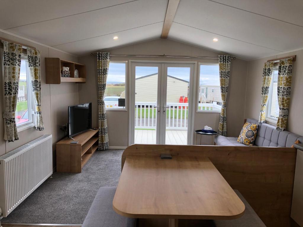 泰恩河畔纽卡斯尔Whitley bay 4 berth Caravan的客厅配有桌子和沙发