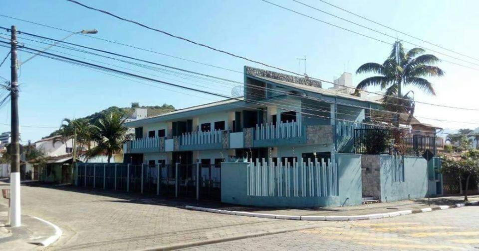 卡拉瓜塔图巴Pousada NOVA Catavento的一条街道旁的蓝色建筑,有栅栏